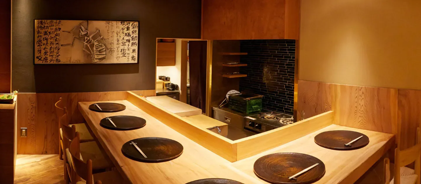 Elegant dining space at Azabu Wakei in Tokyo, featuring wooden tables and a chef's area.