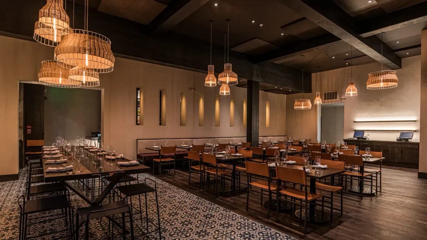 Interior of Aziza restaurant in San Francisco with woven light fixtures and tables.