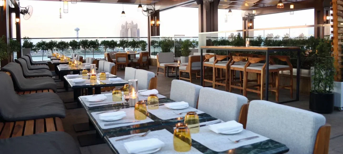 Outdoor dining at Azura Panoramic Lounge in Abu Dhabi with city views and elegant tables.