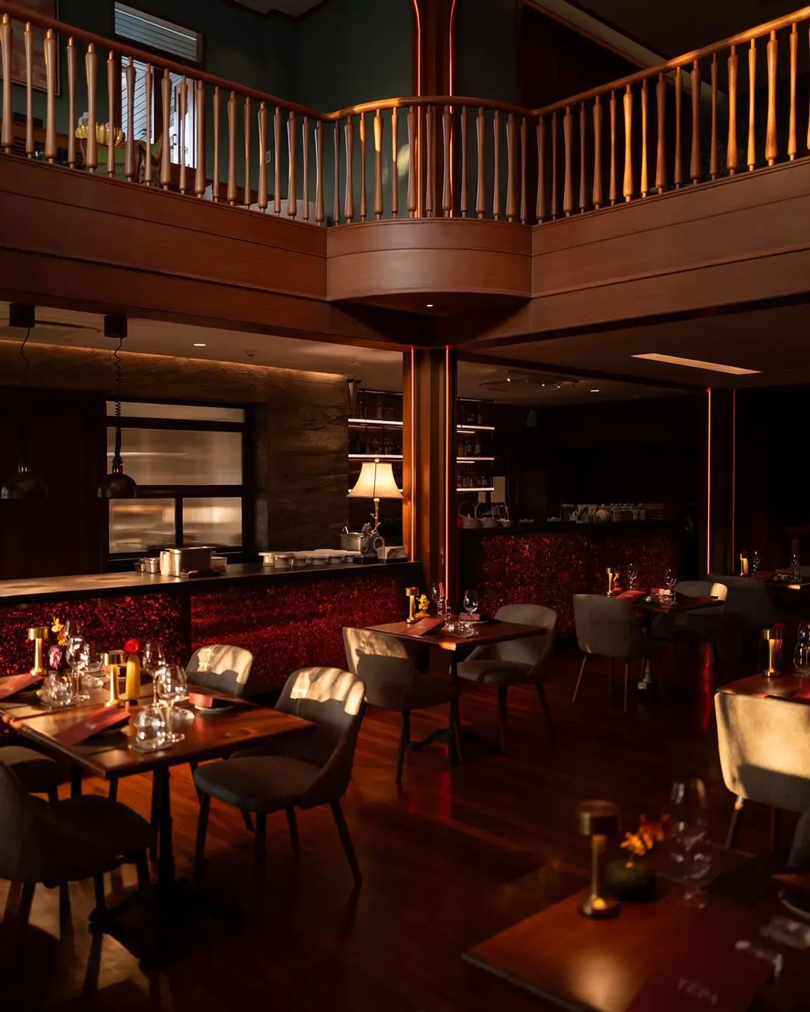 Interior dining space at Baan Tepa restaurant in Bangkok with warm lighting and wooden accents.