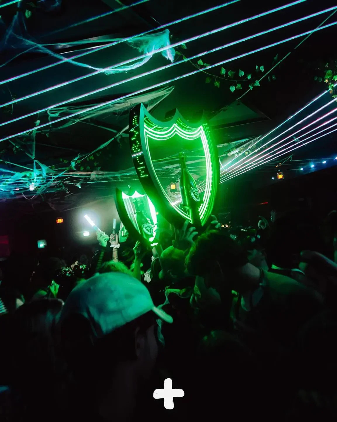 Energetic night at Babenberger Passage nightclub in Vienna, with green neon lights and crowd.