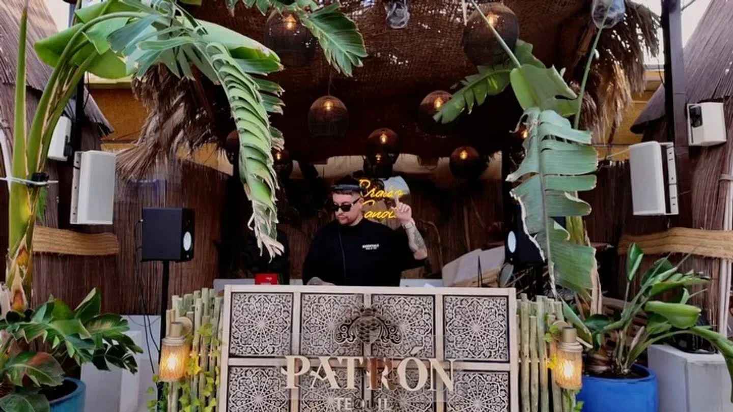 DJ performing at Baloo nightclub in Ibiza with tropical ambiance and ambient lighting.