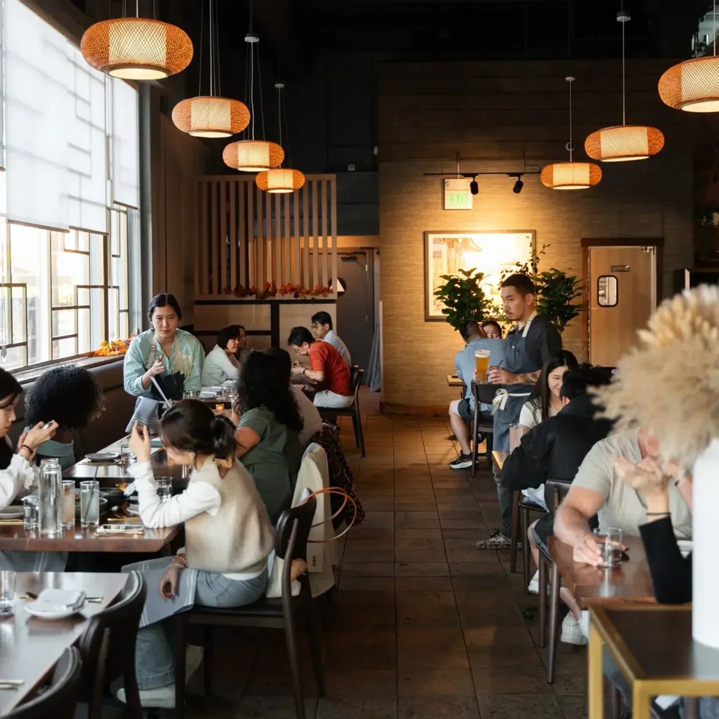 Interior of Bansang restaurant in San Francisco with dining tables and pendant lights.