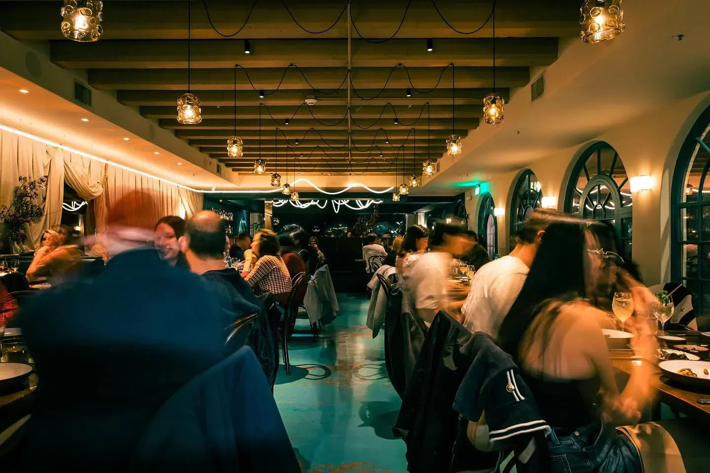 Dining scene inside Bar Chelou in Los Angeles, featuring unique lighting and a lively atmosphere.