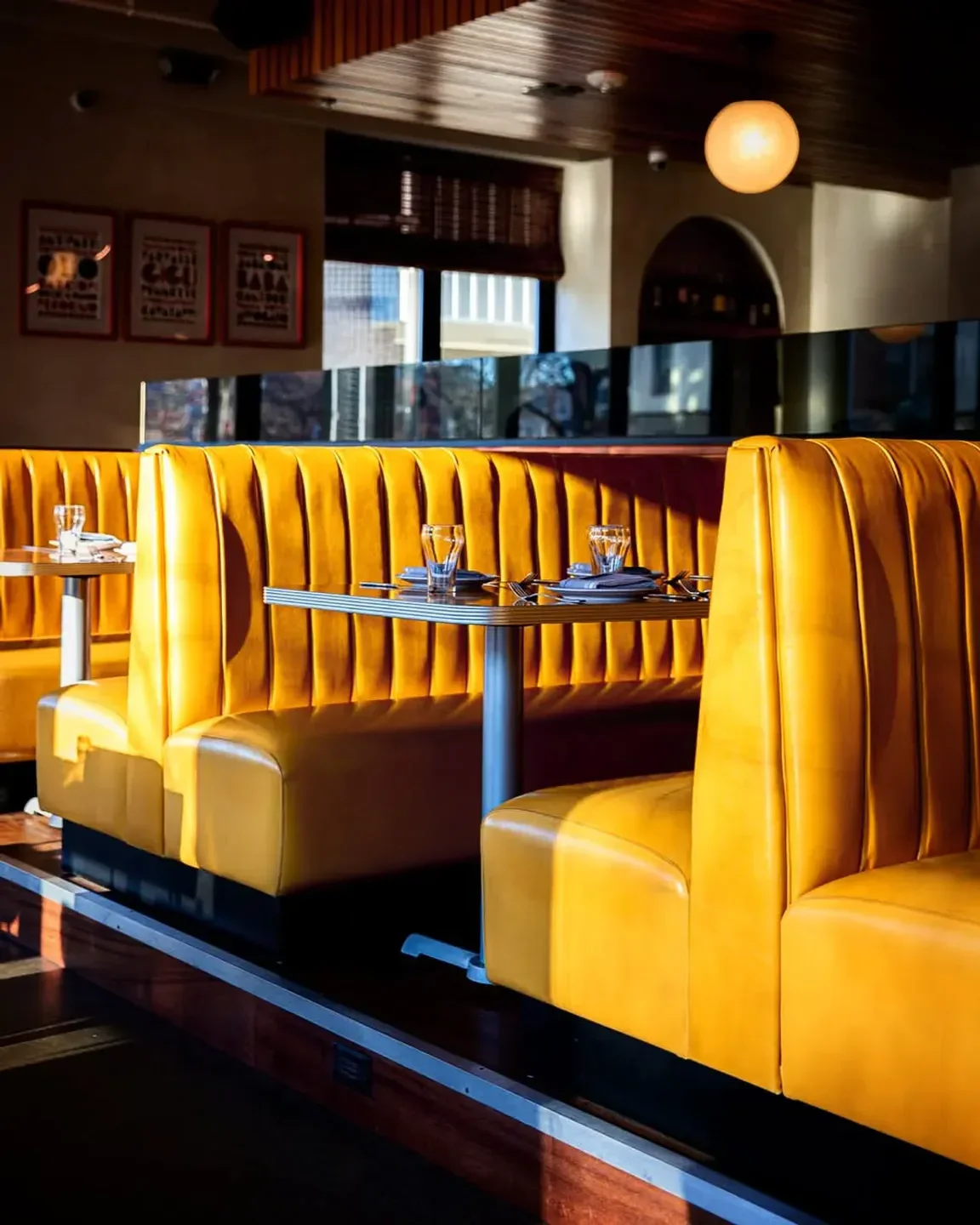 Cozy yellow booths at Bar Volpe restaurant in Boston, perfect for a dinner date.