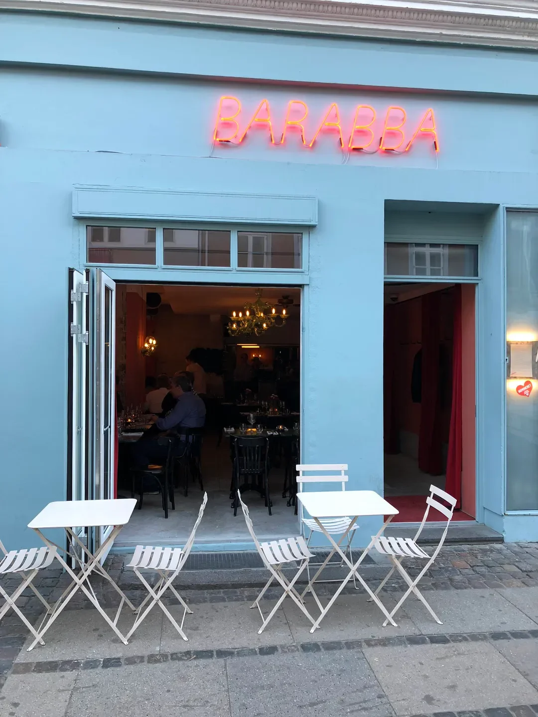 Exterior of Barabba restaurant in Copenhagen with outdoor seating and neon sign.