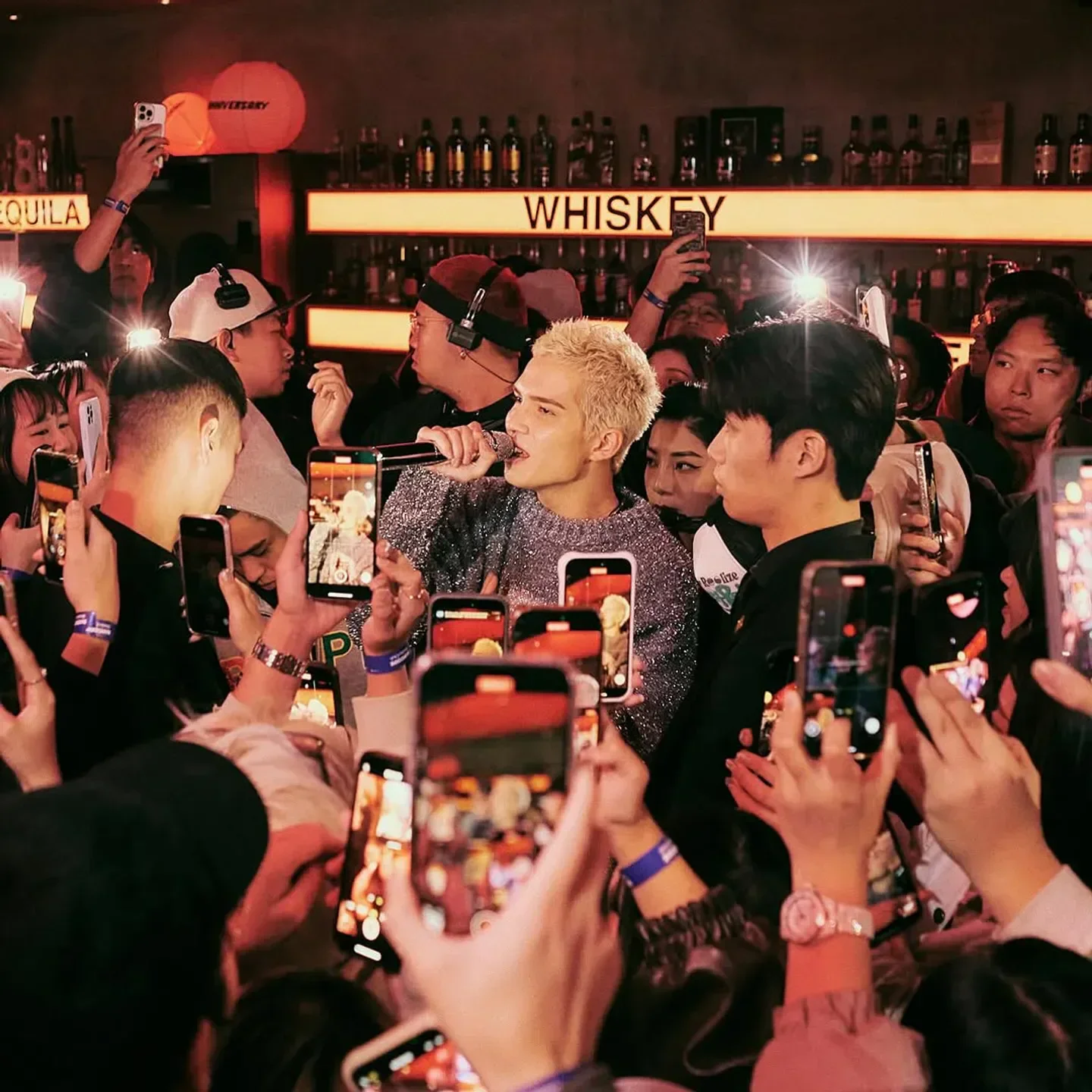 Concert crowd at Barcode Taipei nightclub, many people holding up phones to record singer.