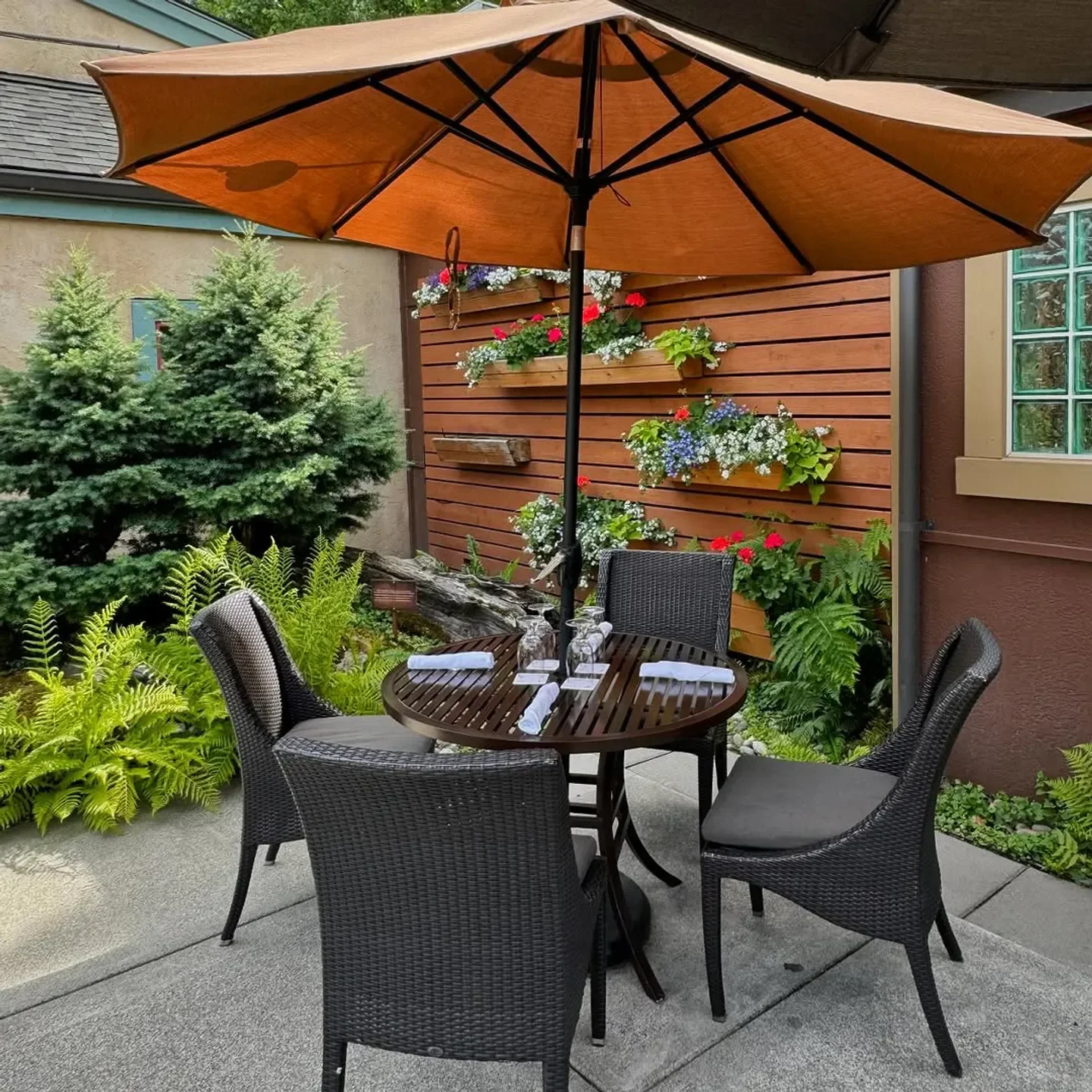 Outdoor dining at Barking Frog in Seattle, with tables under a warm-toned umbrella