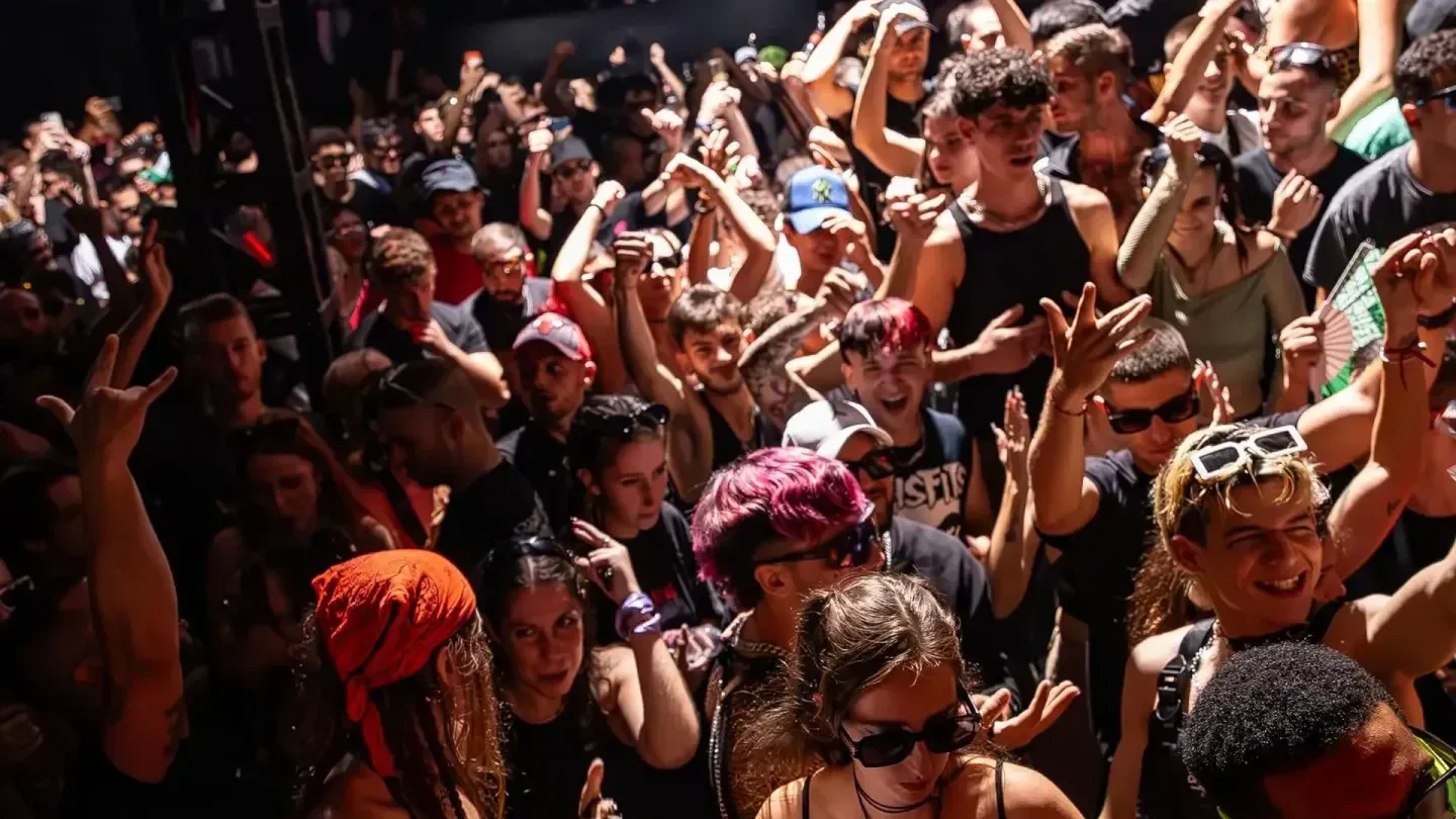 Energetic crowd partying at Barraca nightclub in Valencia, Spain, with hands in the air.