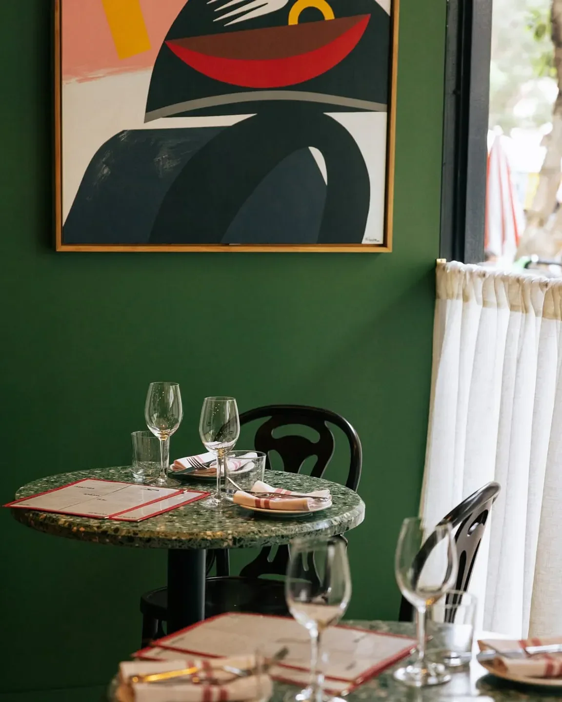 Cozy dining setting at Bastardo restaurant in Sydney, featuring art and a stylish table.