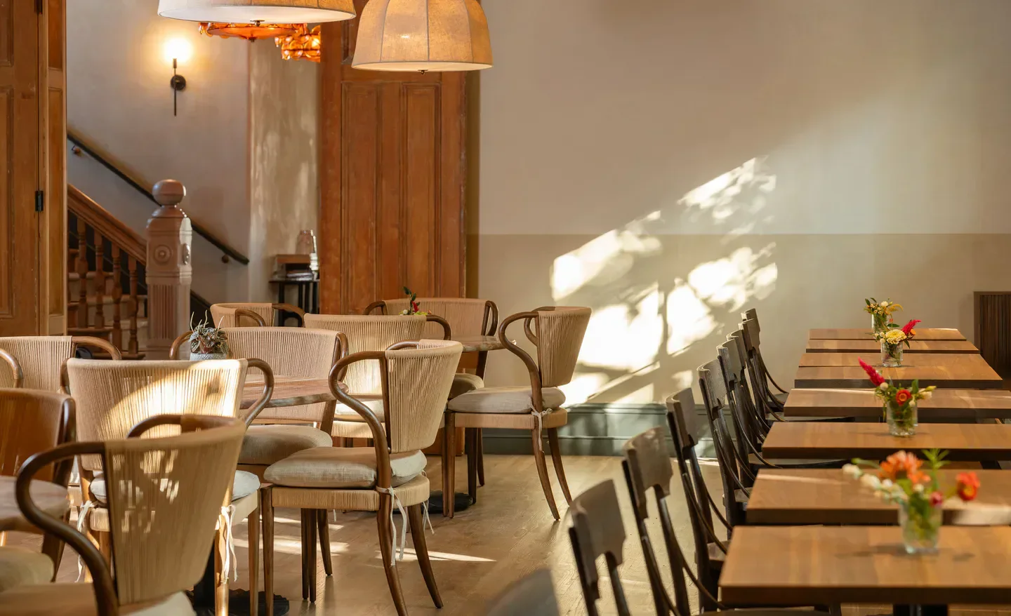 Interior of BASTIA restaurant in Philadelphia, featuring stylish seating and wooden tables.