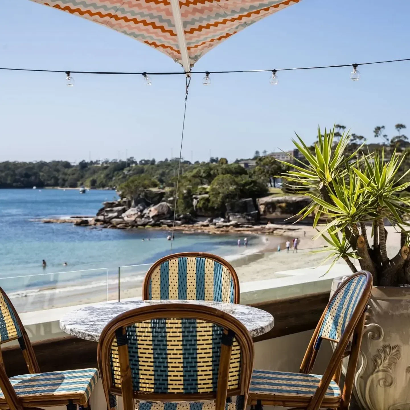 Outdoor seating at Bathers' Pavilion restaurant in Sydney with beach views on a sunny day