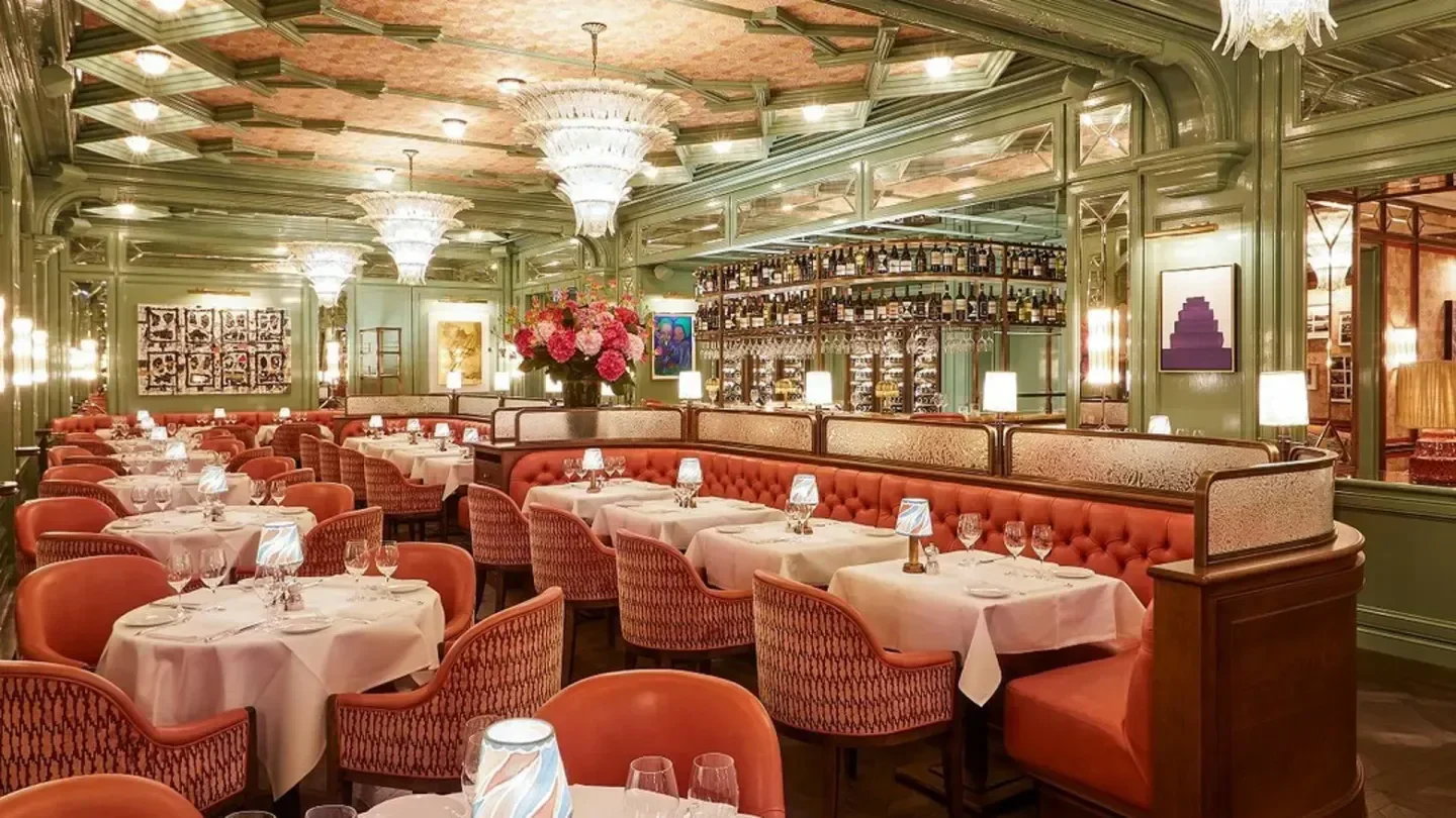 Elegant interior dining room at Baur's restaurant in Zurich, with chandeliers and tables.