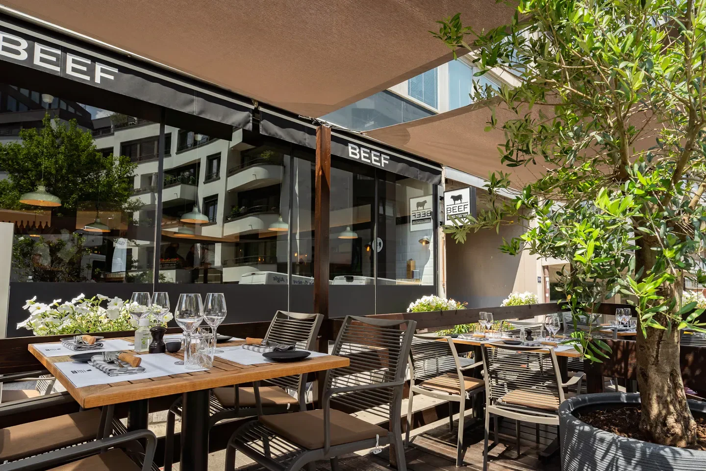 Outdoor seating at BEEF Geneve restaurant in Geneva, Switzerland, with tables set for dining.