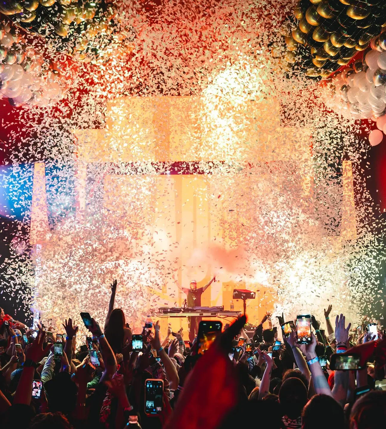 Confetti and crowd at Believe Music Hall in Atlanta, with DJ on stage.