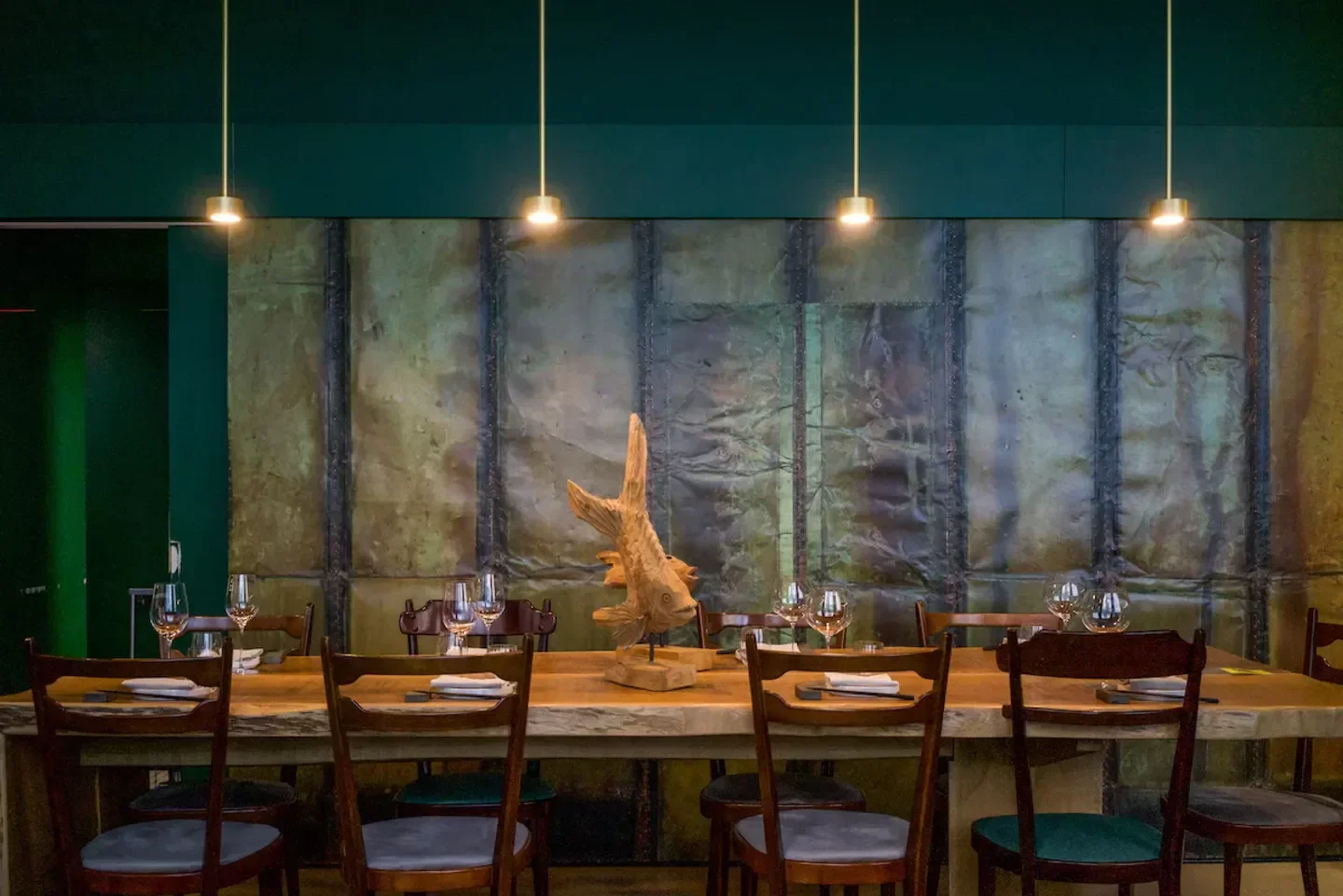 Elegant dining space at Bentoteca restaurant in Milan, featuring artistic decor and lighting.
