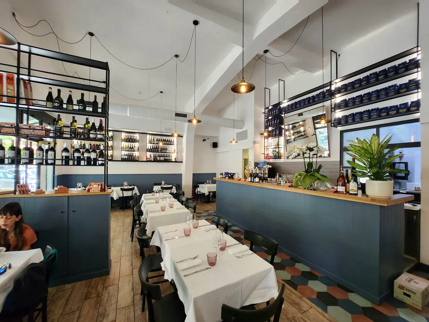 Elegant dining area inside Bianca Trattoria in Rome, featuring a bar and tables.