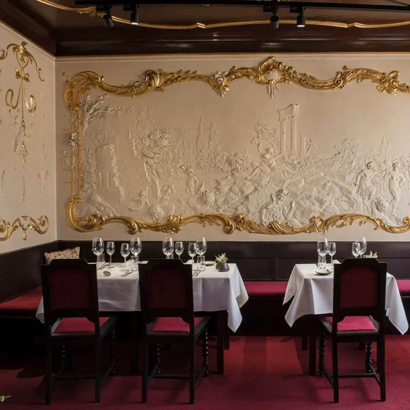 Elegant dining room at Bieberbau restaurant in Berlin, with ornate wall decor and tables