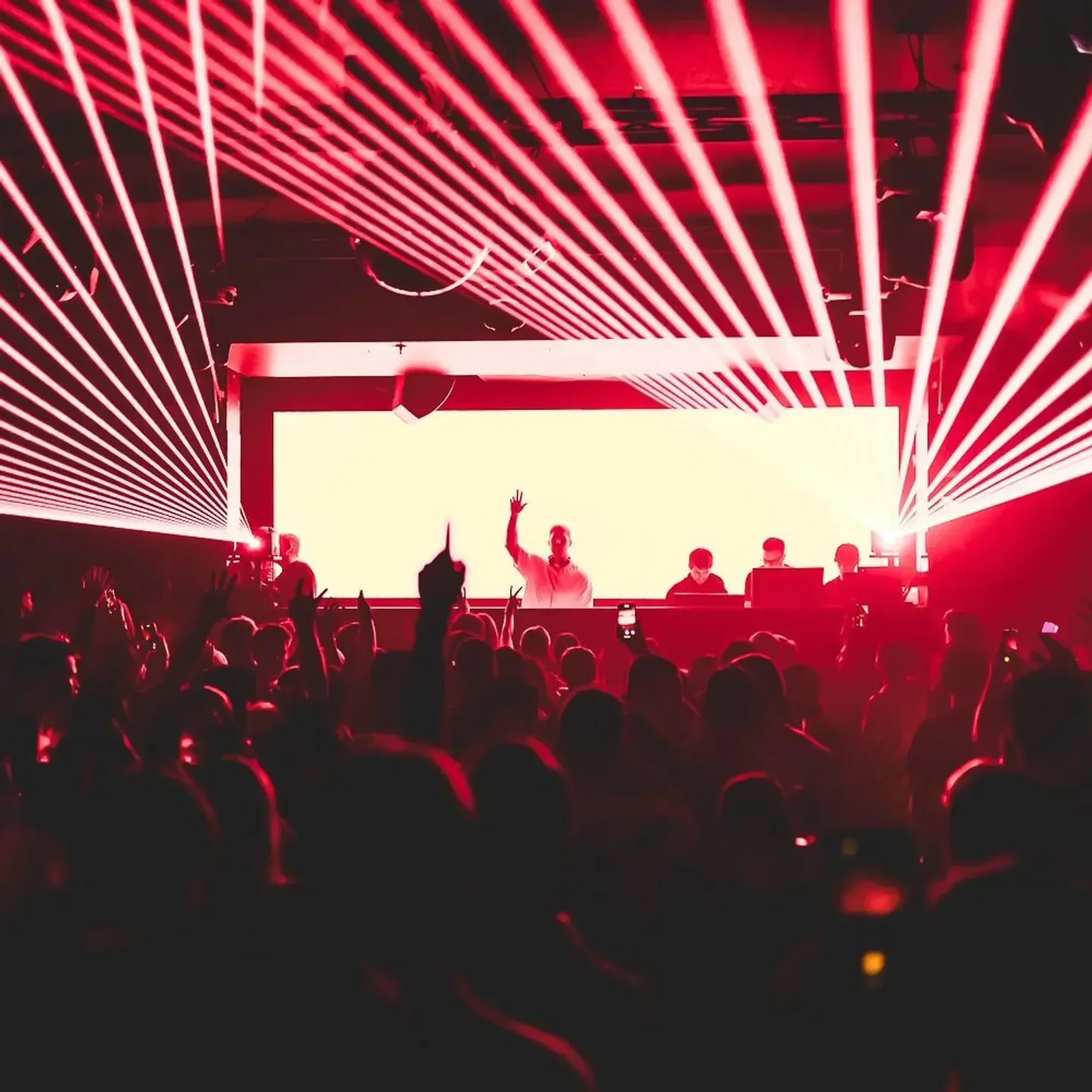 Energetic crowd at Bijou Boston nightclub with DJ and vibrant red lighting.