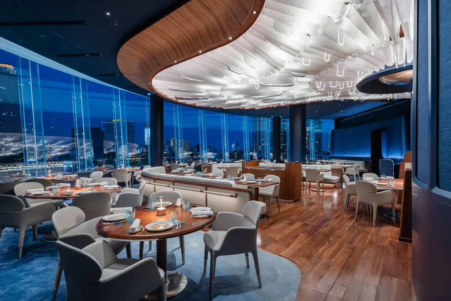Elegant interior of Blue by Alain Ducasse restaurant in Bangkok with city views.