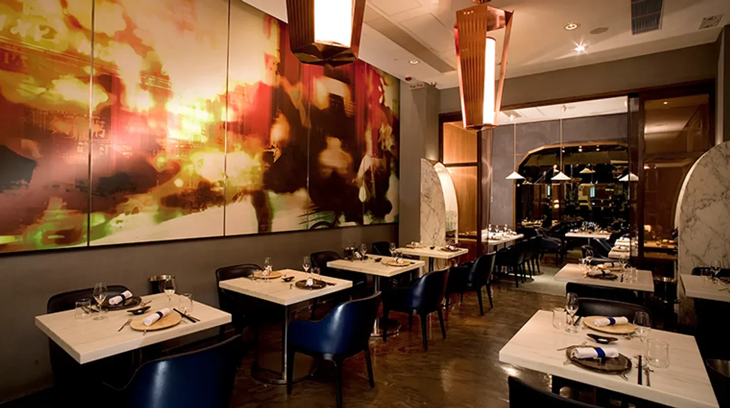 Interior of Bo Innovation in Hong Kong with stylish tables and artwork on the wall.