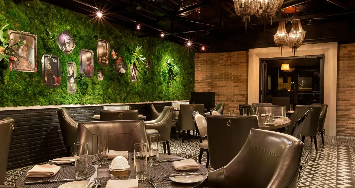 Interior of Boka in Chicago featuring a stylish moss wall and elegant dining space.