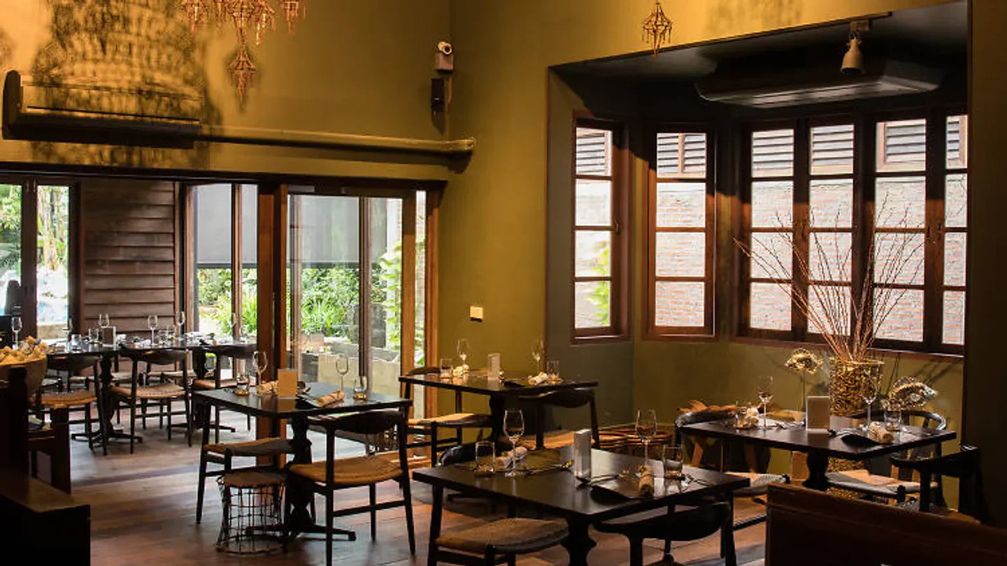 Interior dining space at Bo.Lan restaurant in Bangkok, featuring tables and natural light.