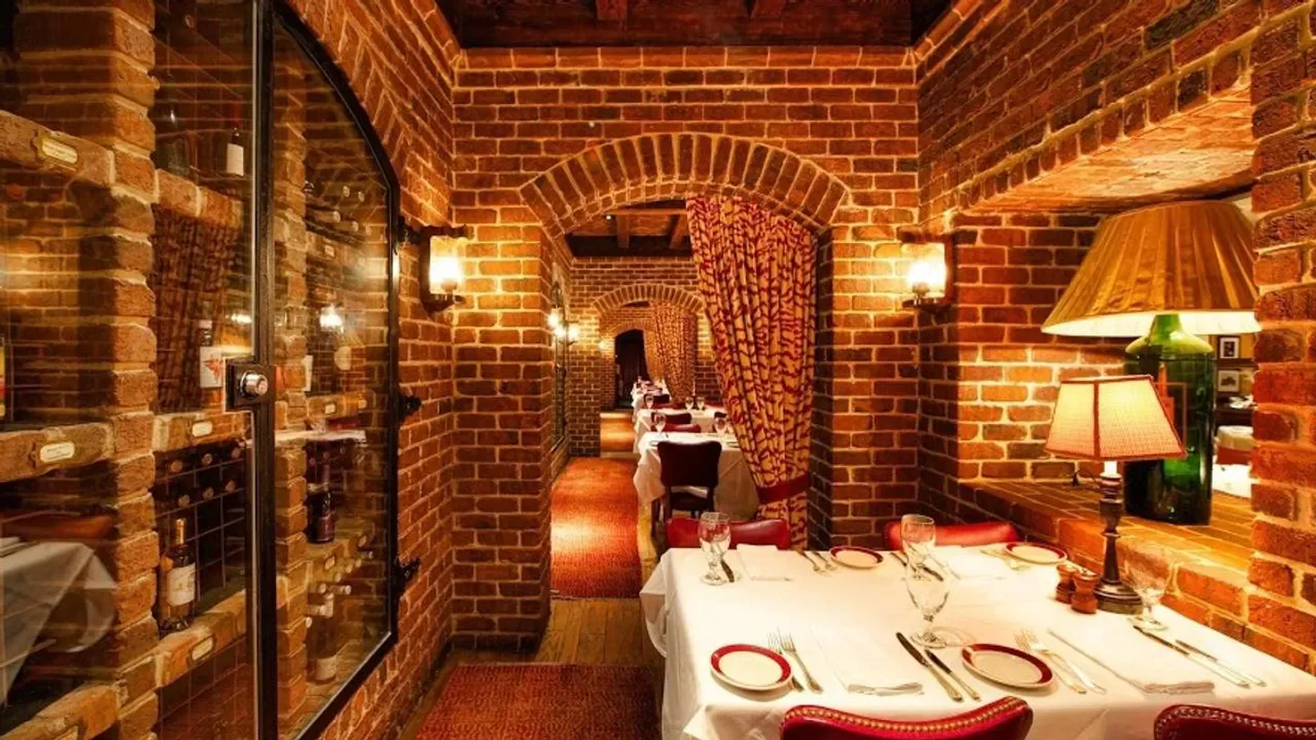 Cozy dining area at Bones restaurant in Atlanta, featuring brick walls and elegant tables.