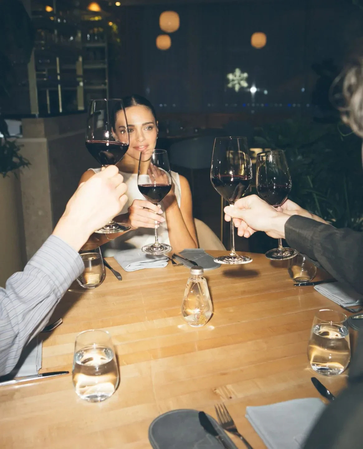 Cheers at Botanist Vancouver restaurant. People enjoying drinks at a dining table.