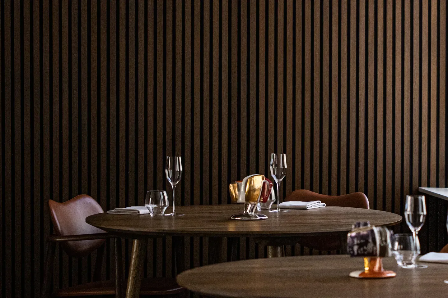 Cozy dining setting at Brace in Copenhagen, featuring a round table and wine glasses.