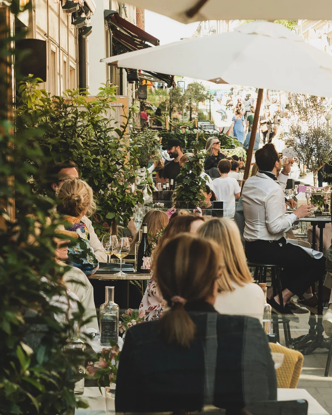 Guests dining al fresco at Brasserie Astoria, enjoying the lively atmosphere of the city.