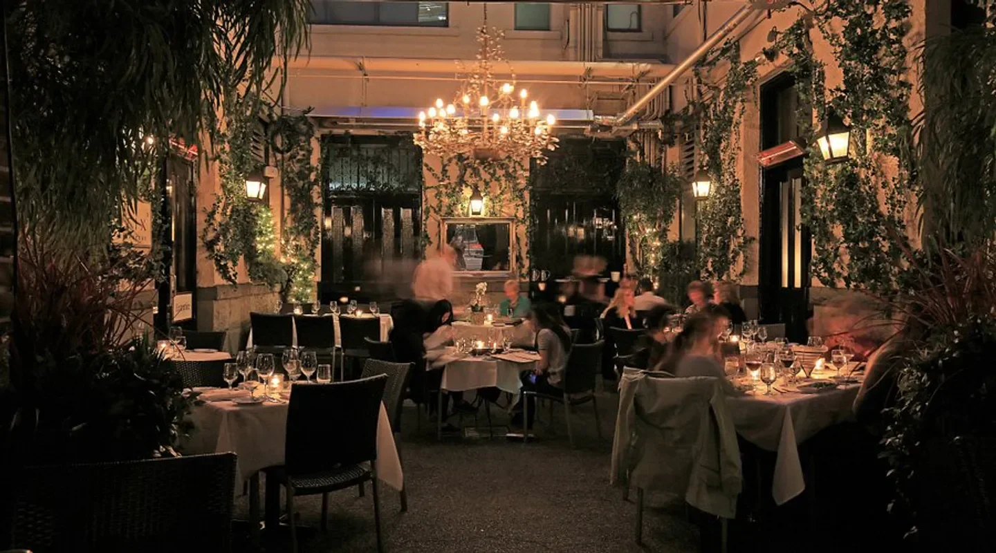 Romantic dinner setting at Brix and Mortar restaurant in Vancouver, with lush greenery.