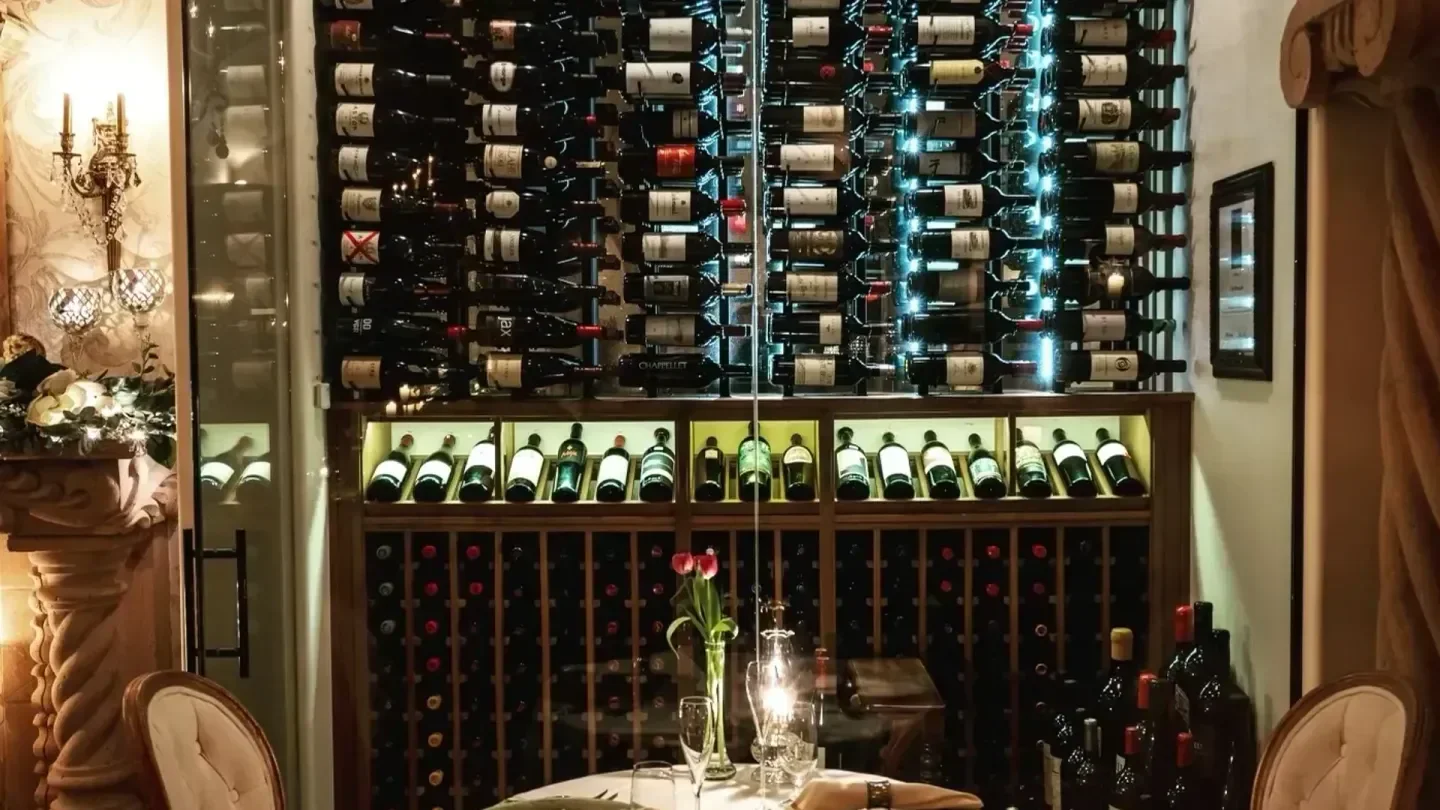 Wine cellar inside Café Monarch in Scottsdale, with bottles and a dining table.