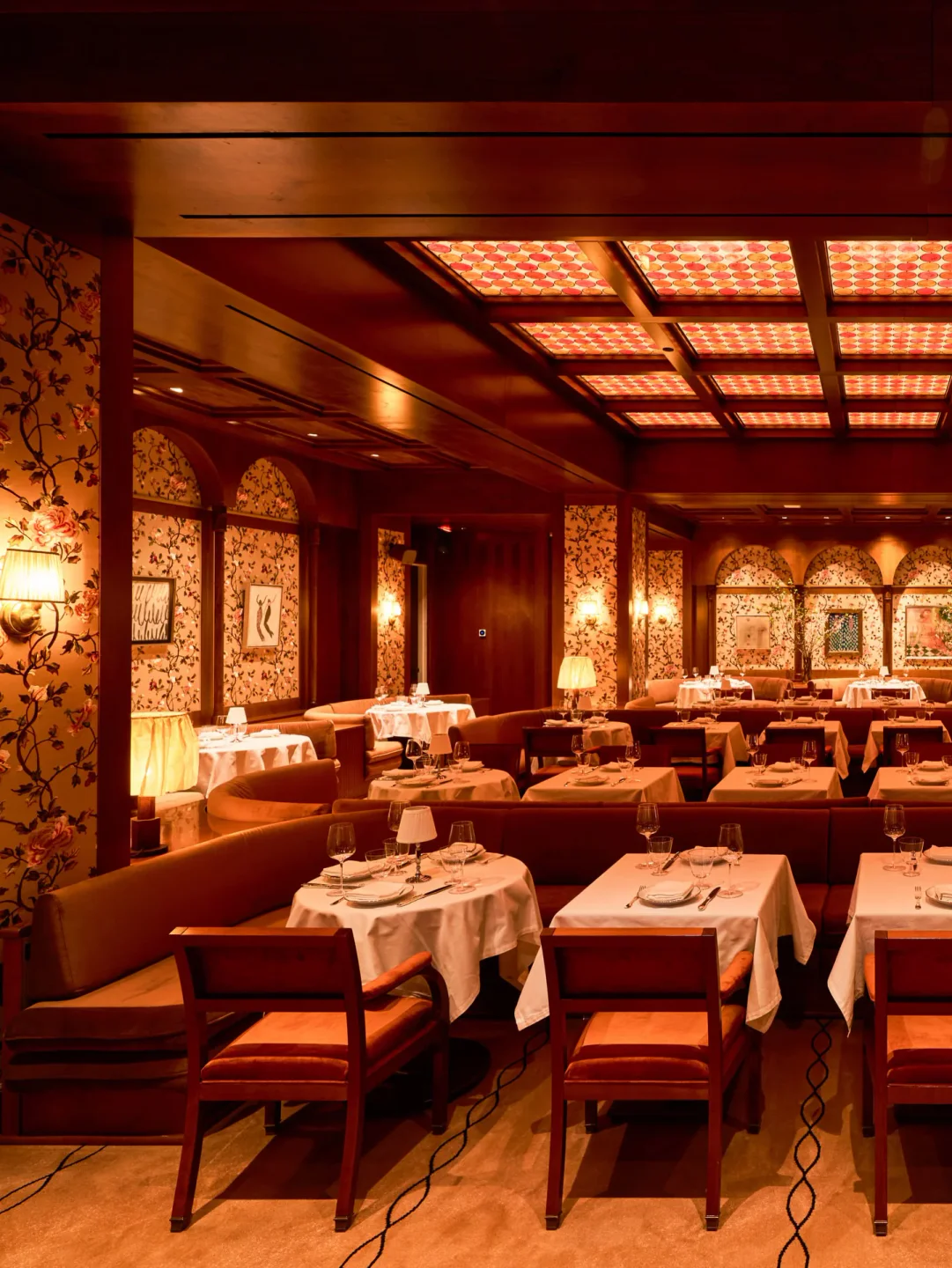 Elegant interior of Cafe Zaffri restaurant featuring floral wallpaper, plush seating, and ambient lighting in the city.