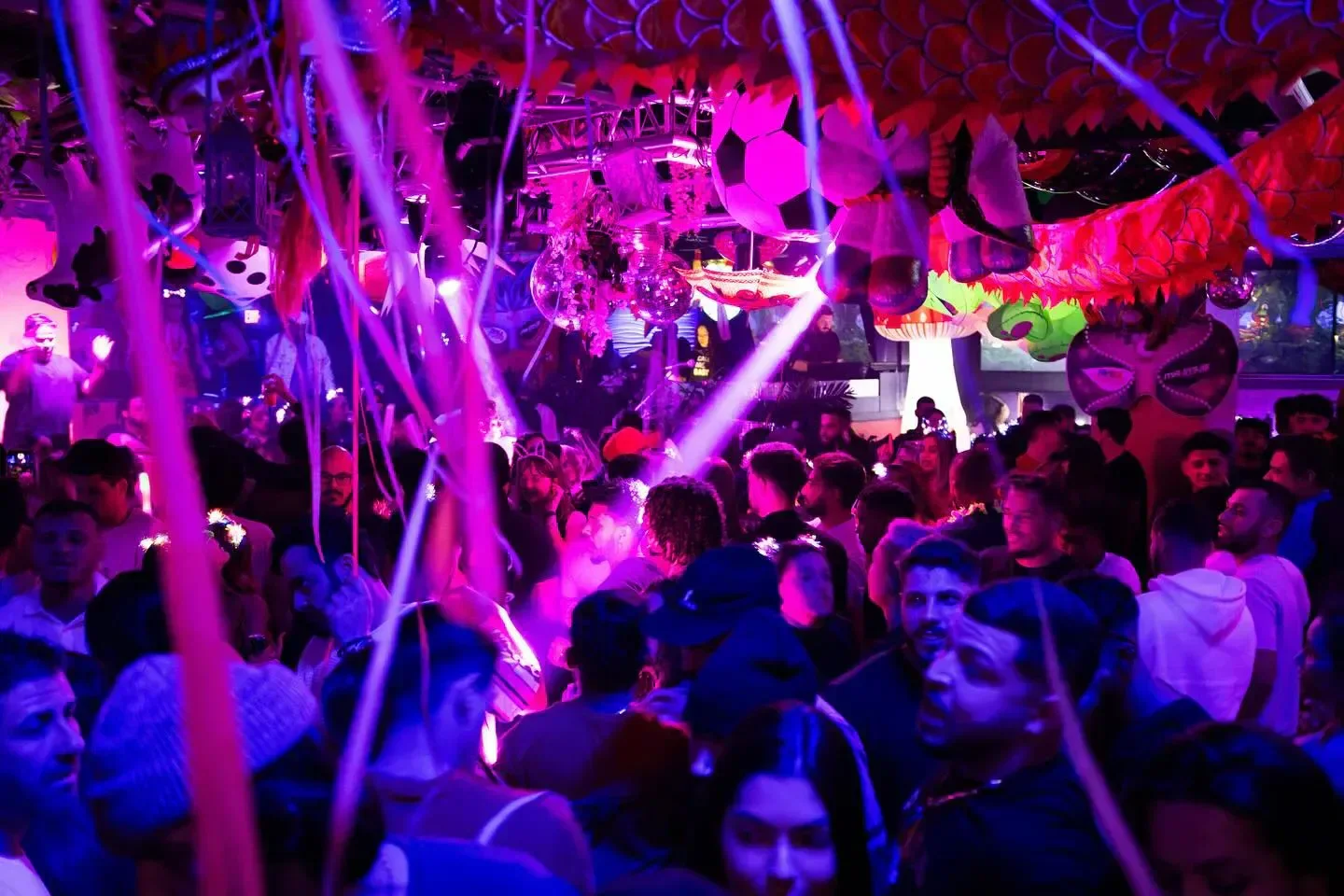 Energetic crowd at Candibar nightclub in Boston, with festive decorations and lighting.