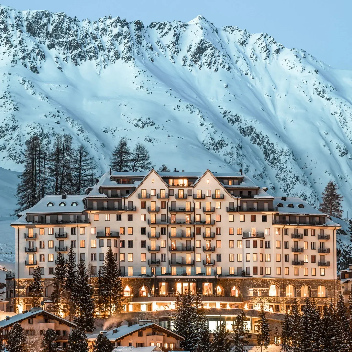 Carlton Bar & Bel Etage in St. Moritz, luxury hotel facade with snowy mountain backdrop