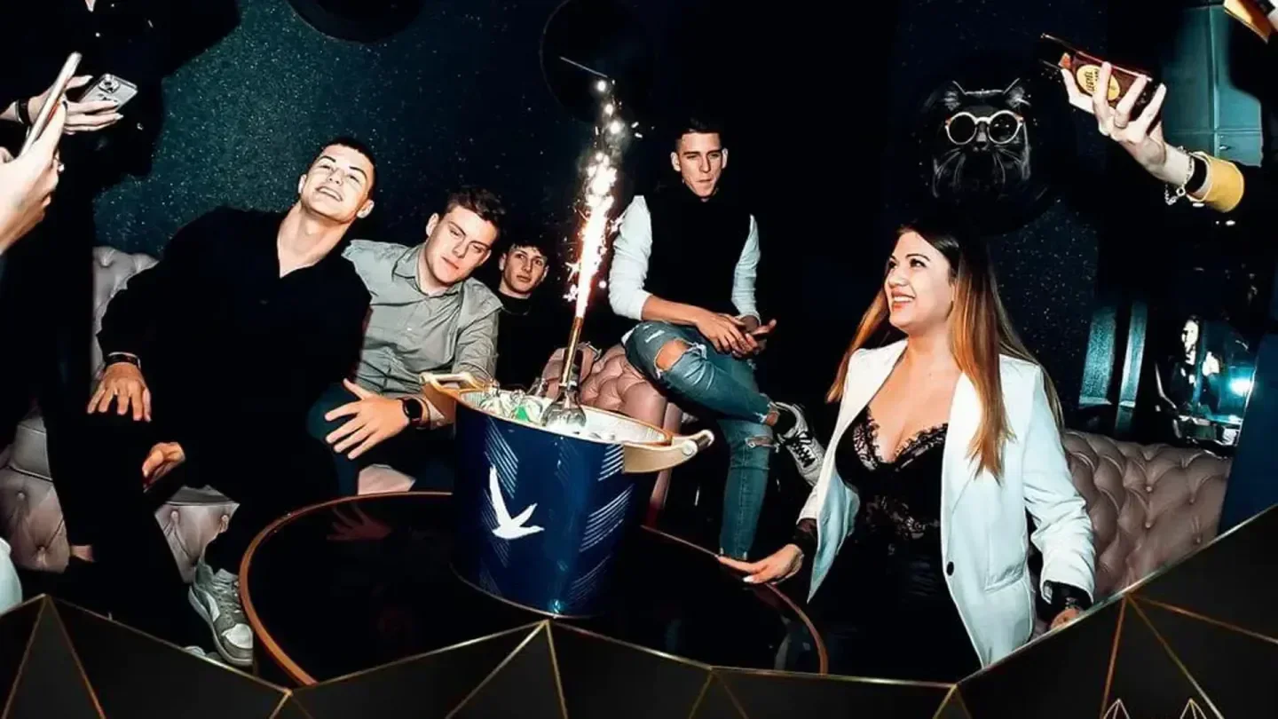 Group of friends partying at CAT Budapest nightclub in Budapest, celebrating with drinks.