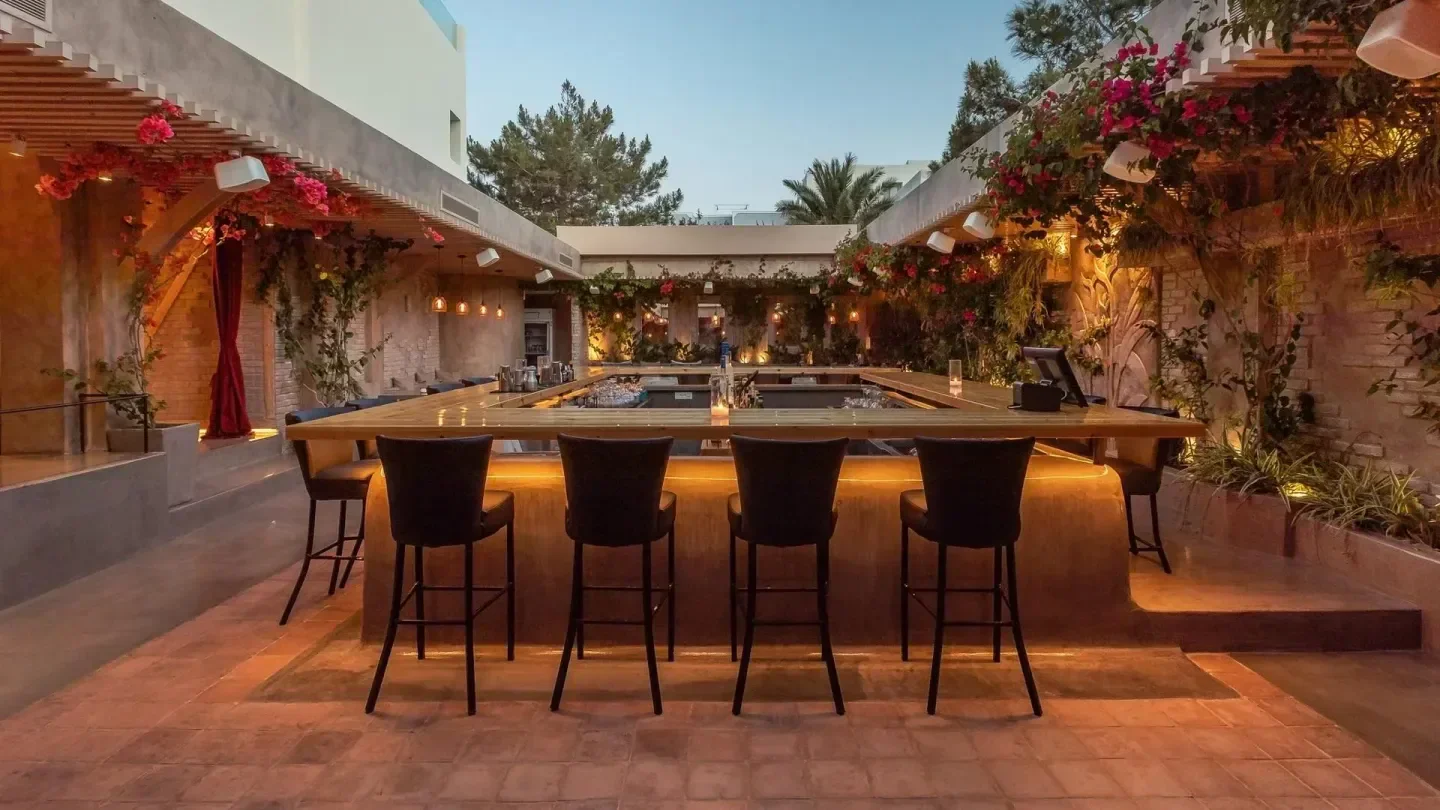 Catch Santorini: Stylish outdoor bar with lush flowers and ambient lighting.