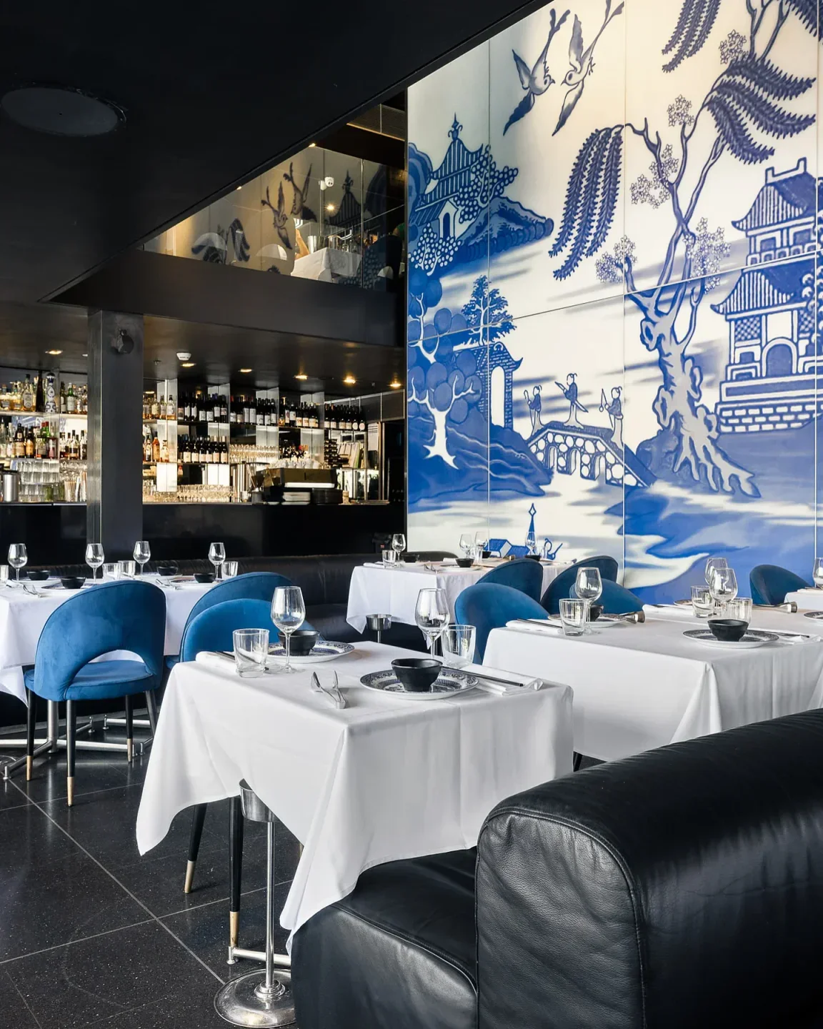 Elegant dining at China Doll in Sydney, featuring stylish decor and serene blue artwork.