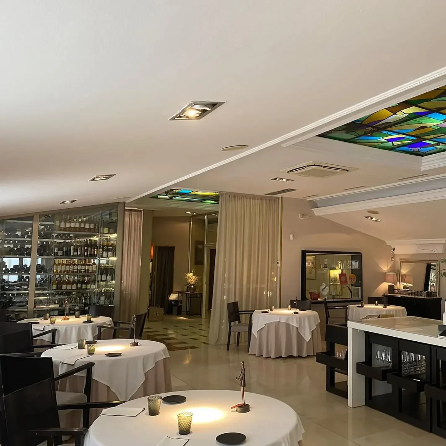 Elegant interior of Chirón restaurant in Madrid, showcasing tables and wine display.