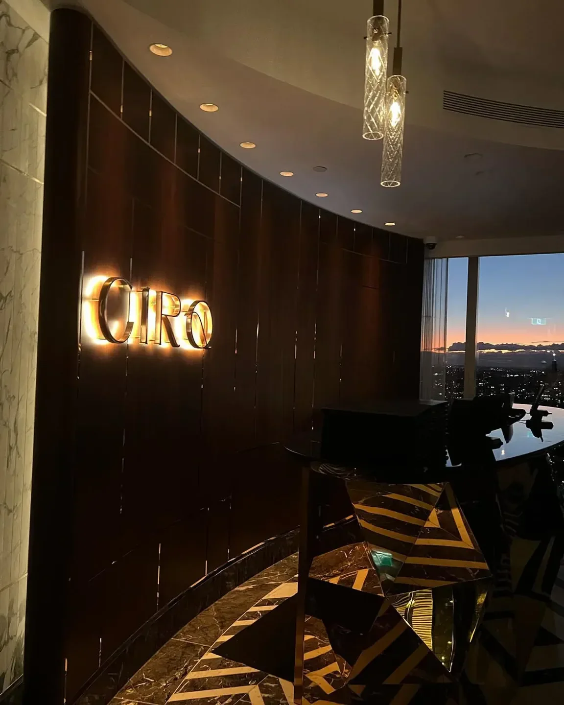 CIRQ Sydney restaurant interior with stylish decor, city views, and warm ambient lighting.