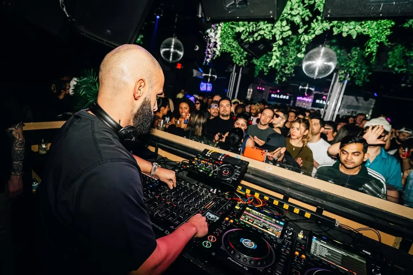 DJ at Club Ego Afterhours in Las Vegas with a packed crowd and flashing lights.