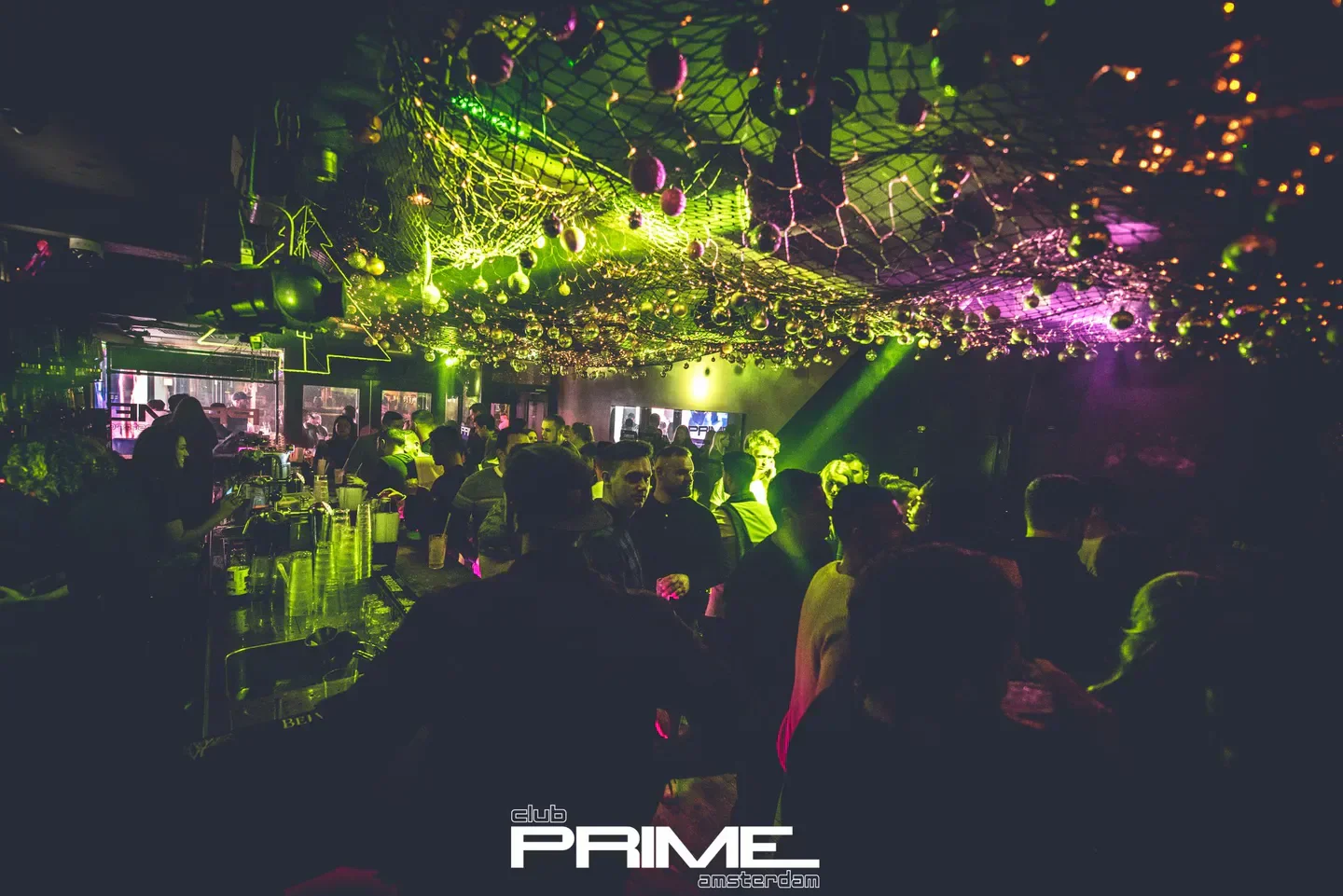 Inside Club Prime in Amsterdam: vibrant nightclub scene with colorful lighting and lively crowd.
