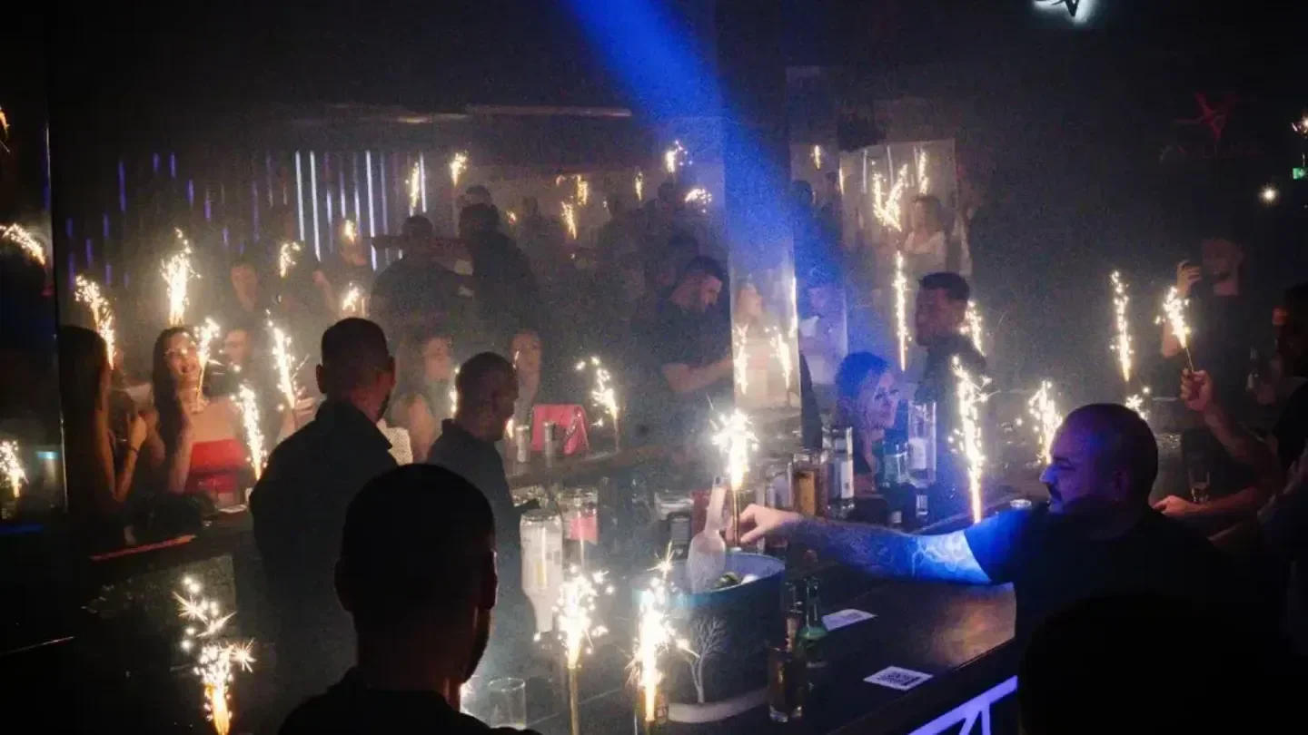 Sparkling celebration inside Club Village nightclub in Vienna, with a busy crowd and bar.