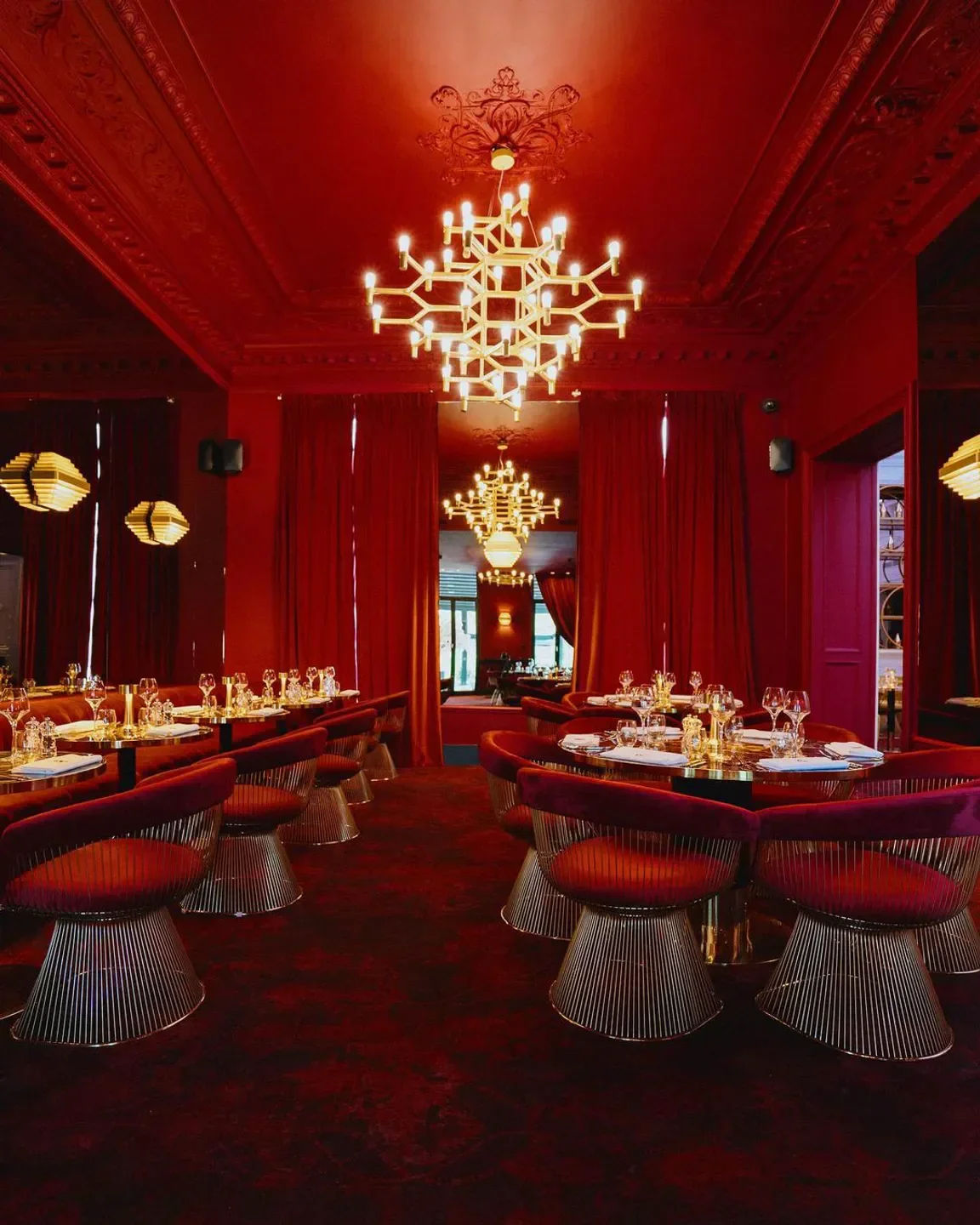 Elegant red interior of COCO restaurant in Brussels with stylish seating and lighting.