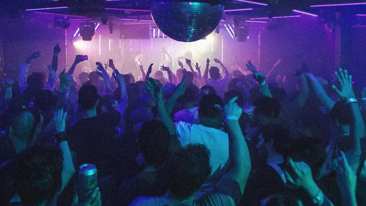 Energetic crowd at Coda nightclub in Toronto, dancing under a disco ball.