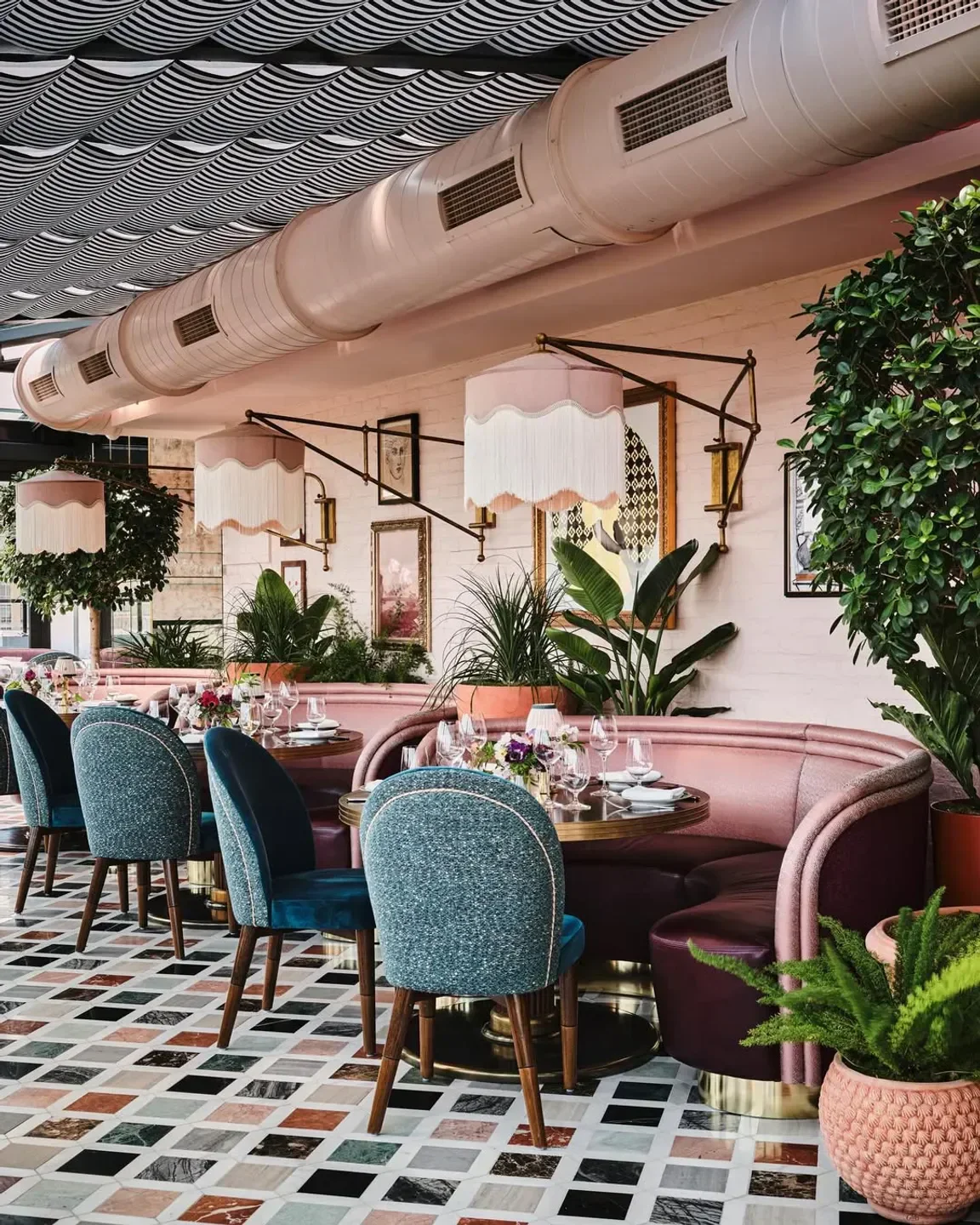 Stylish interior dining at Contessa Boston restaurant, featuring elegant decor and lush plants.