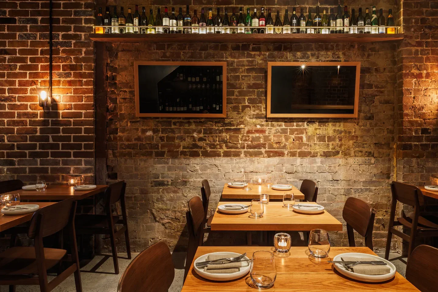 Coogee Wine Room in Sydney, interior shot with brick walls, tables and wine bottles.