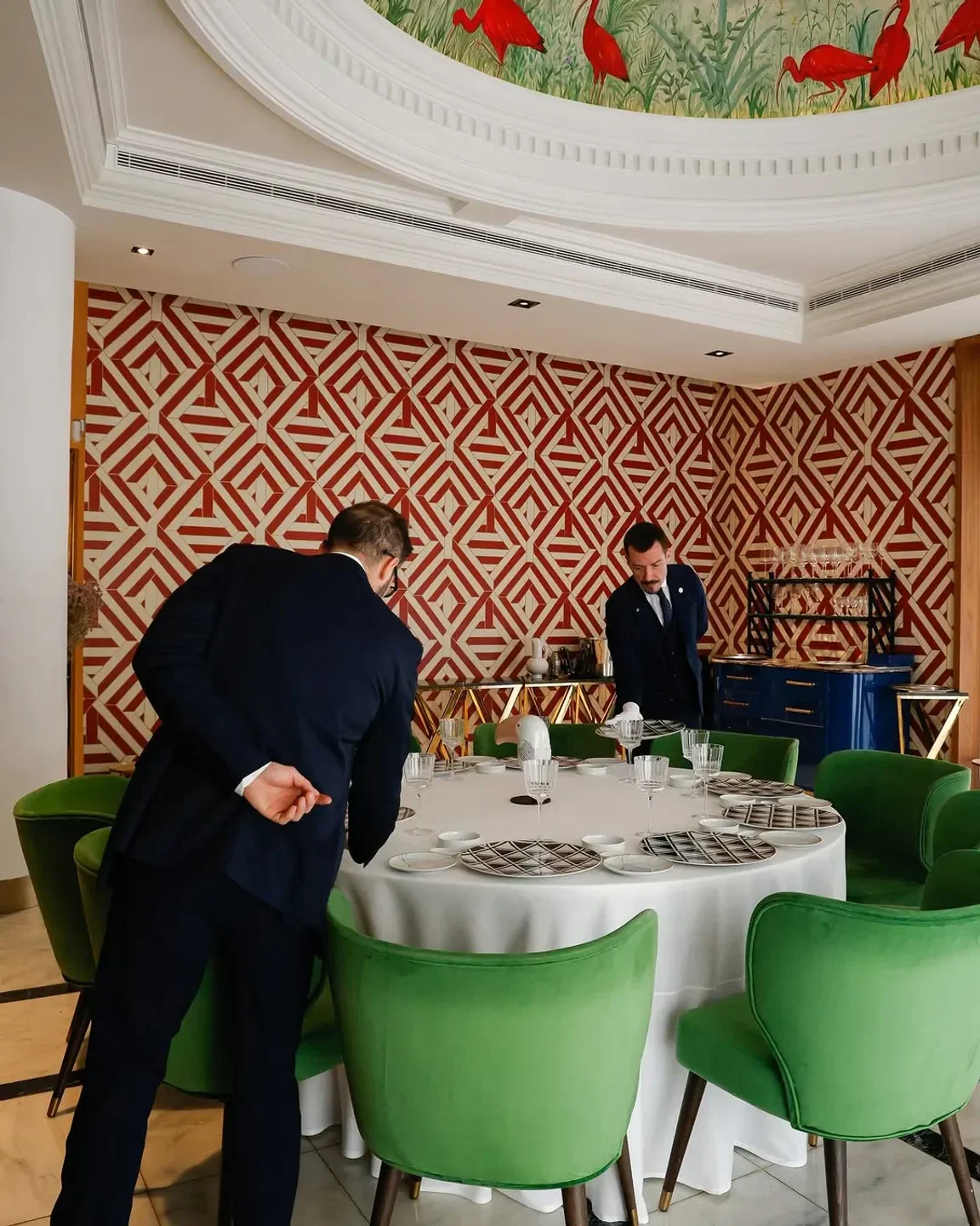 Elegant dining room at Coque restaurant in Madrid, with staff preparing for service.