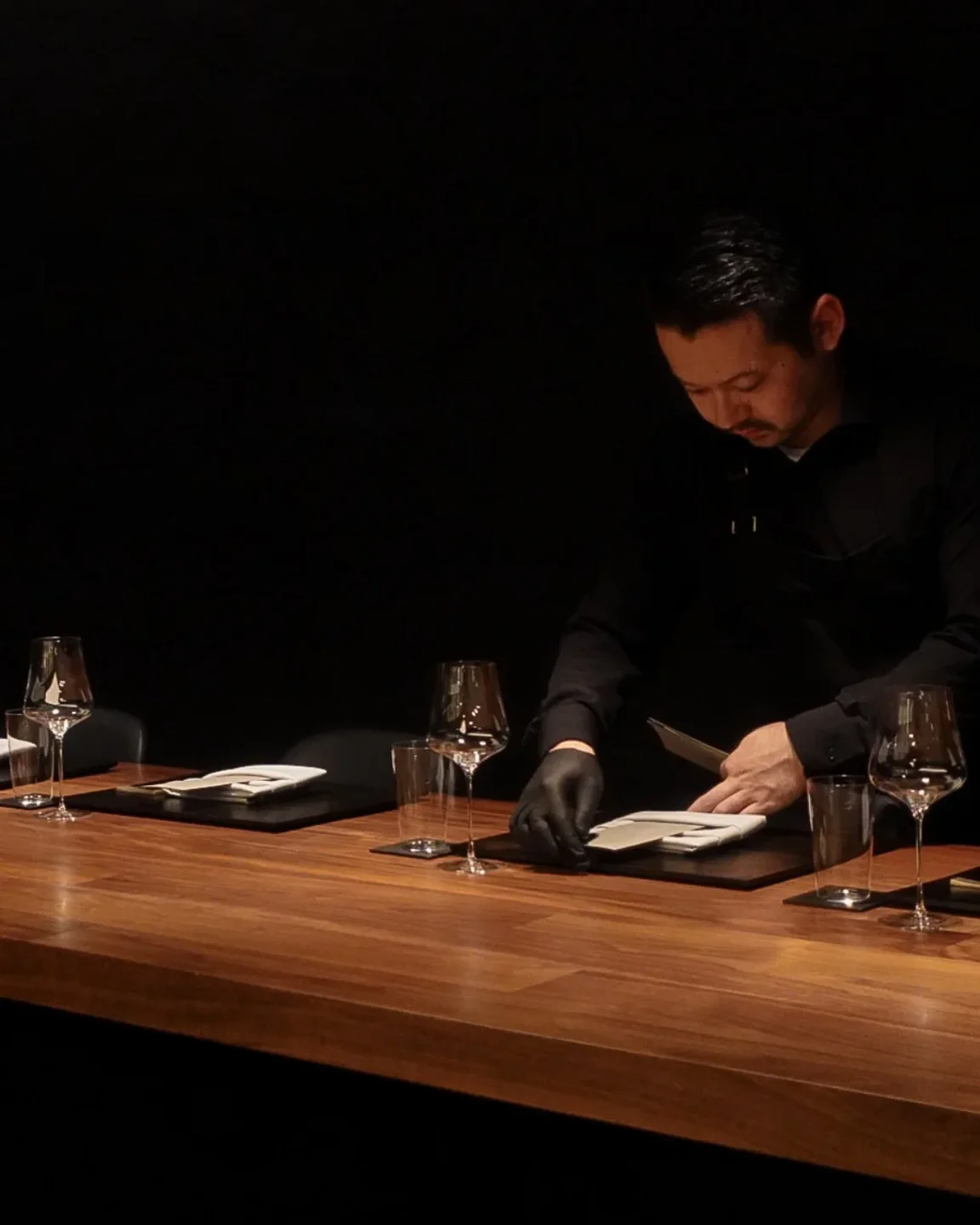 Corridor 109 restaurant staff setting table with wine glasses and menus in the city.